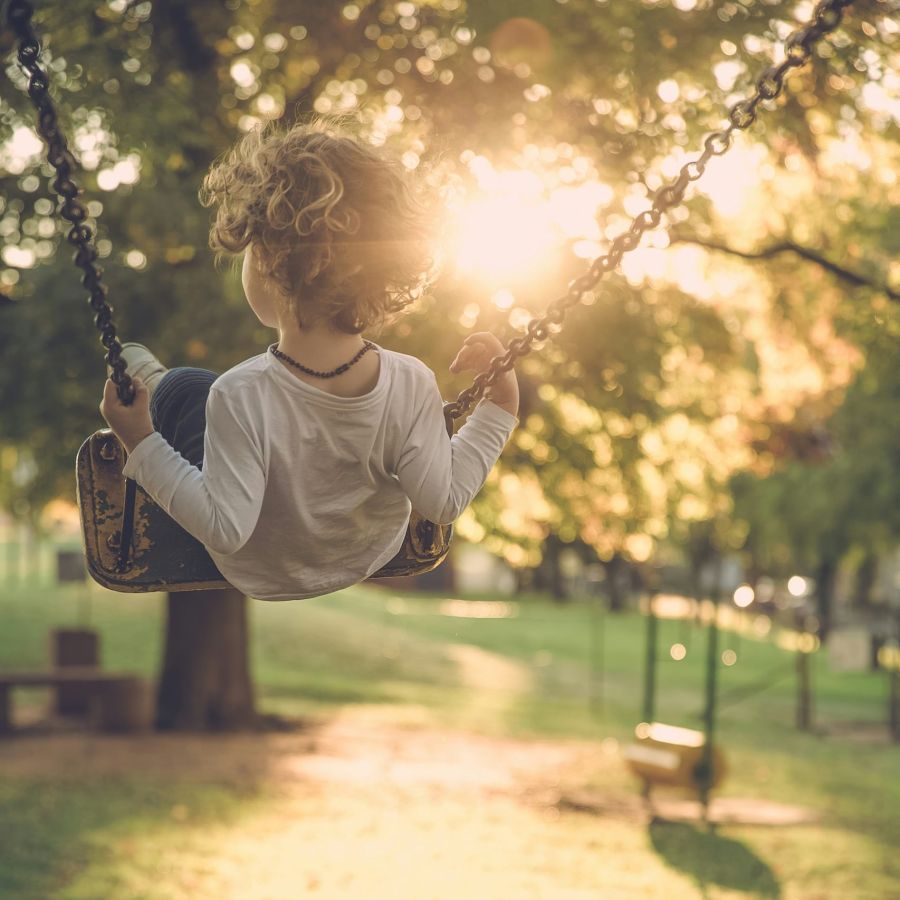 child on swing in park